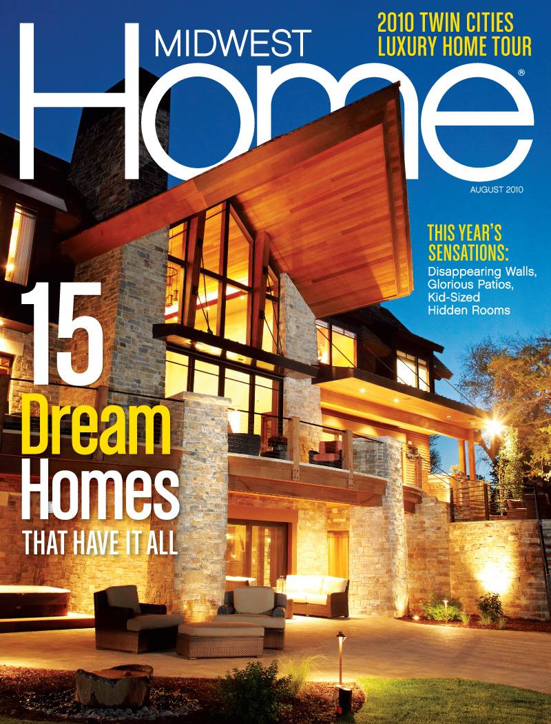 Midwest Home Magazine Cover for August 2010 showing a mountain lodge themed home at dusk light up by exterior lights. The a-framed cantilever roof towers out over 20 feet and the window extend two stories.