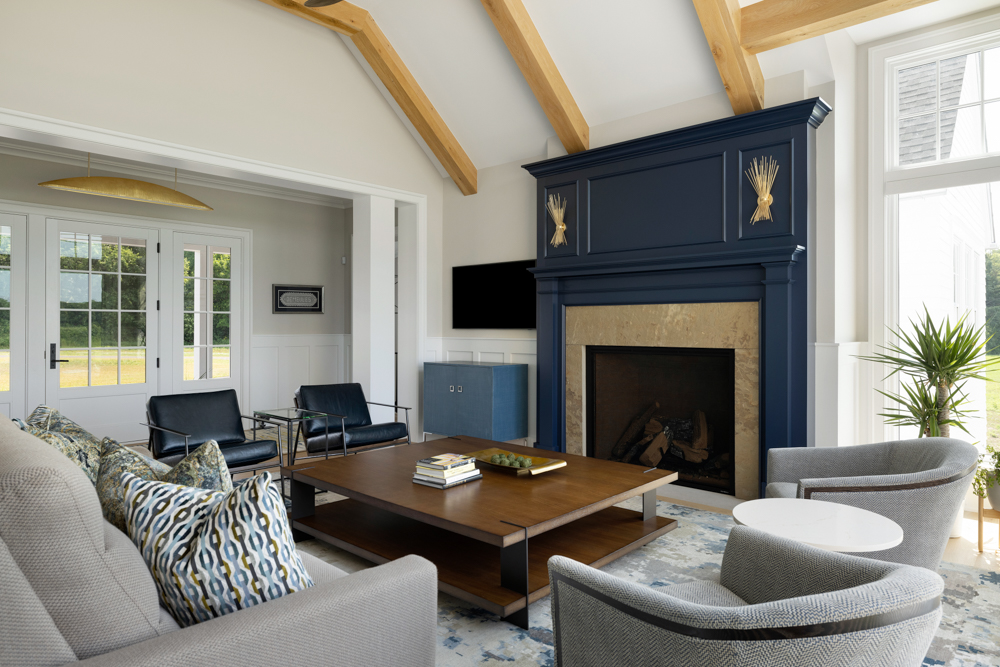 Living room blue fireplace and white walls with exposed light maple beams
